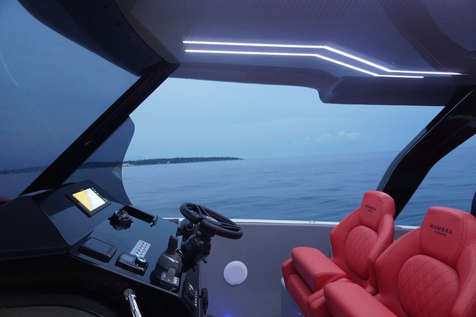 Kumbra 36 helm with red seats, navigation displays and open sea
