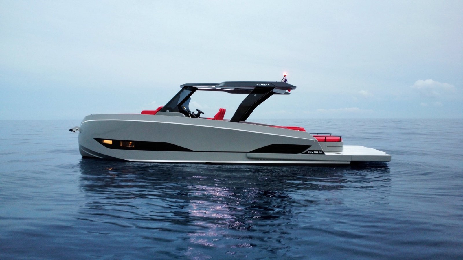 Side profile of a grey Kumbra 36 on calm water