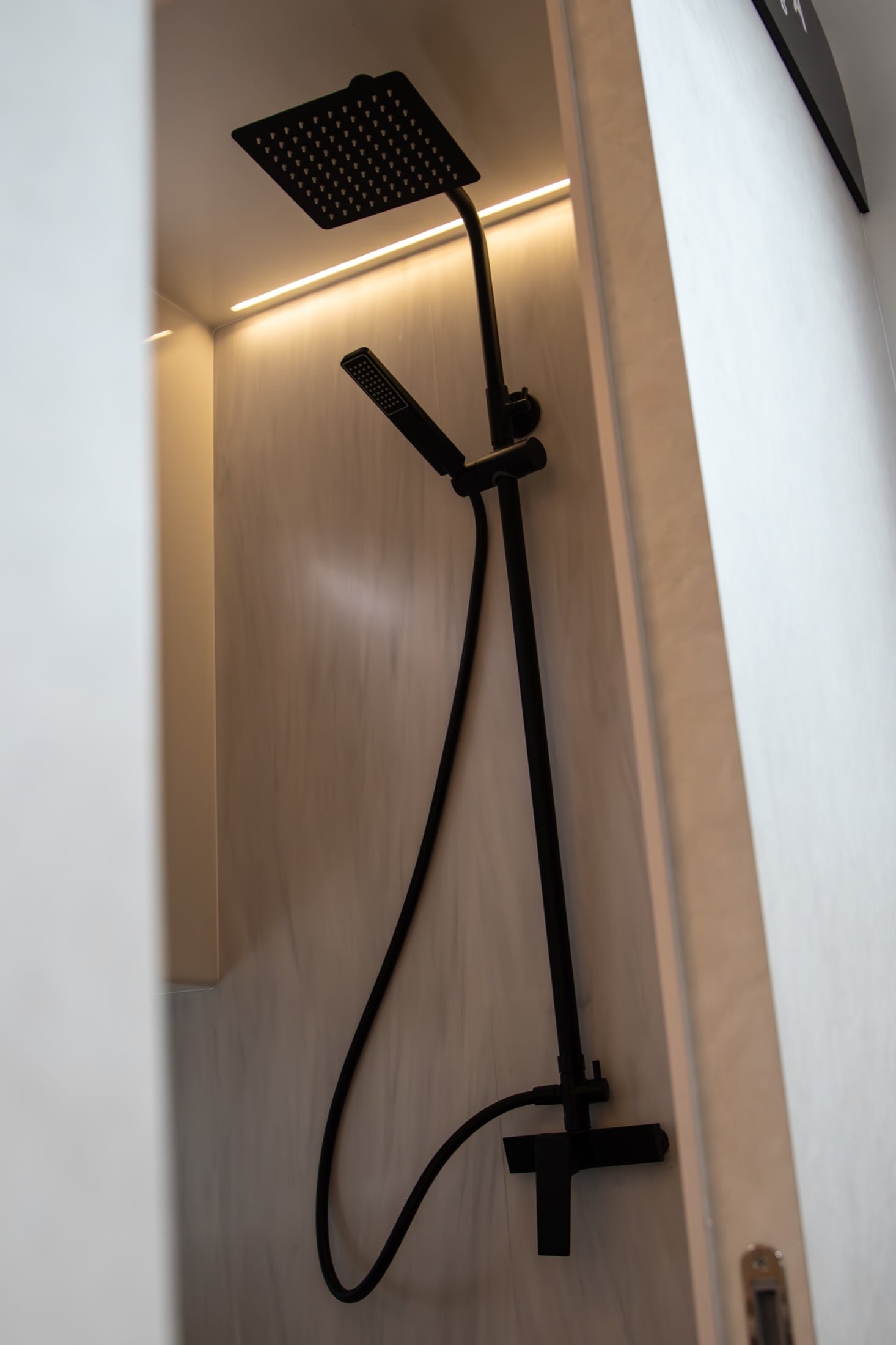 Black rainfall and handheld shower fittings in the Kumbra 43 bathroom